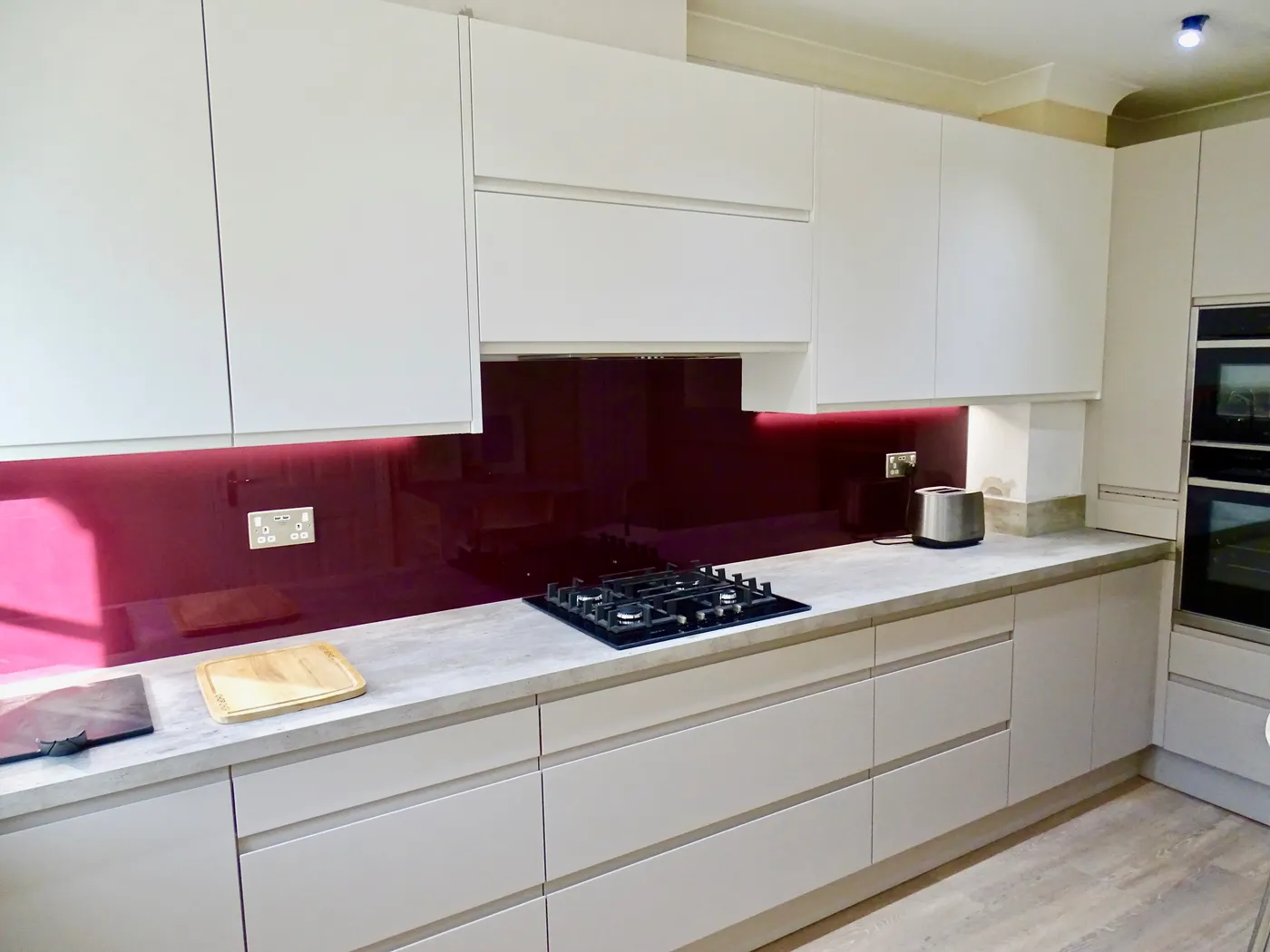 Handleless Grey Kitchen with Burgundy Splashback — project photo