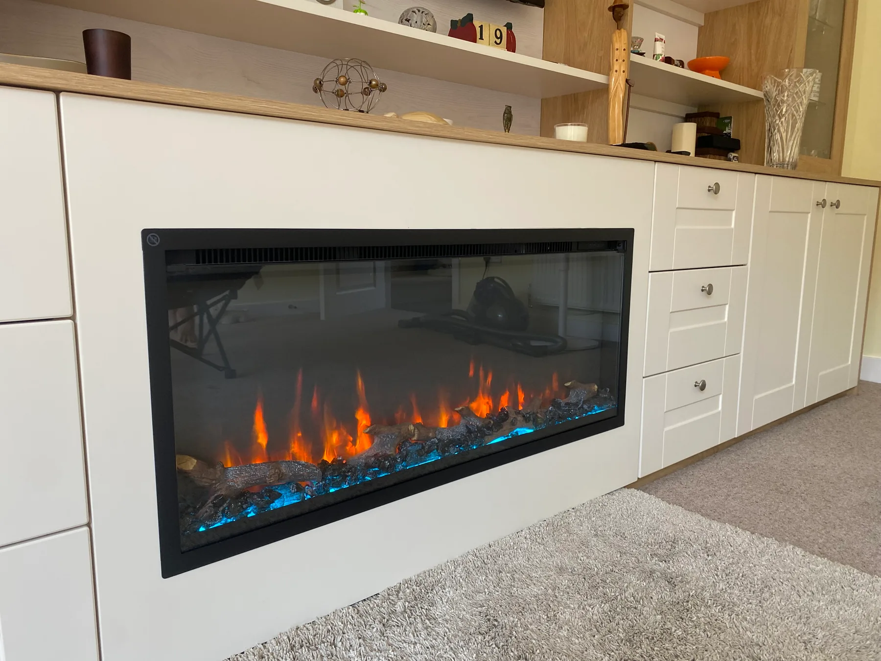 Fitted lounge cabinetry with fire and shelving niches