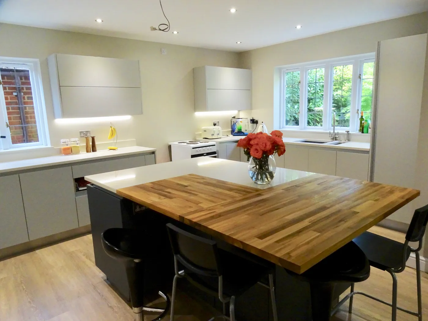 Greige Handleless Kitchen with Oak Breakfast Bar — project photo