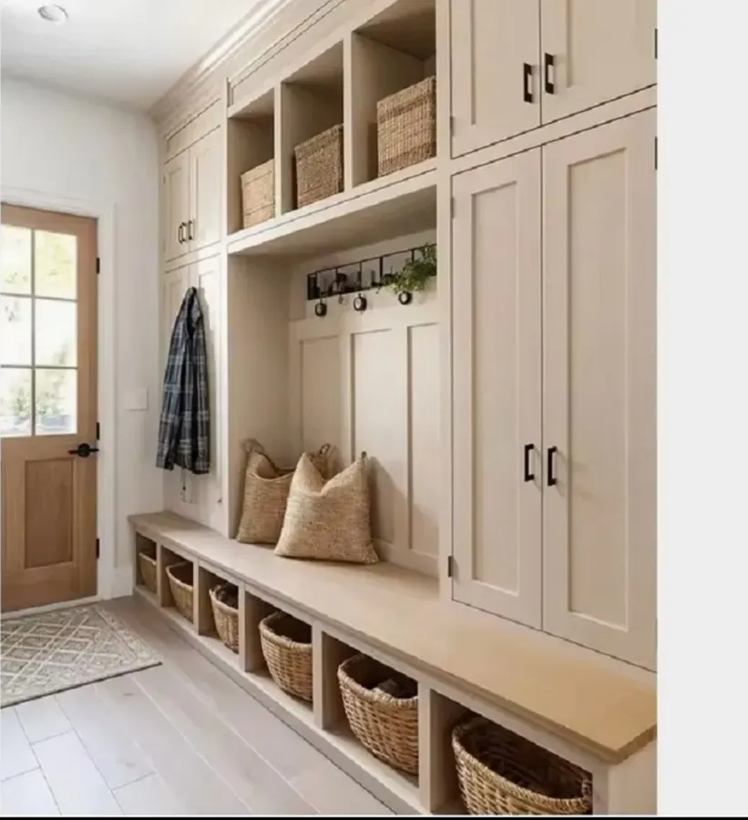 Full-height cream hallway cabinetry with bench and basket cubbies