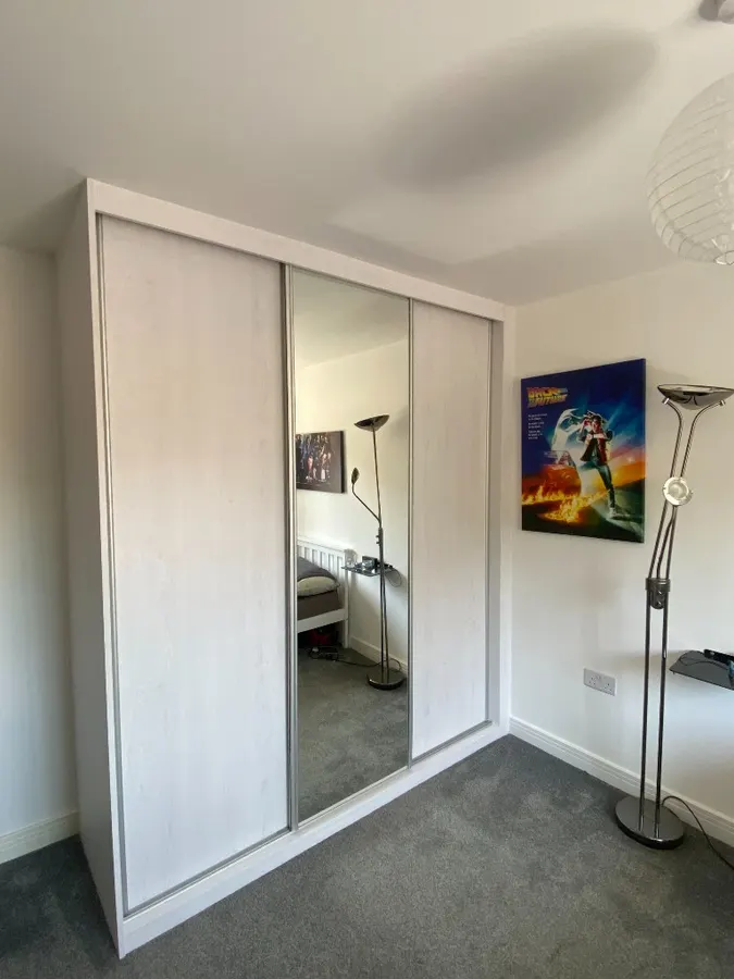 White-frame sliding wardrobe with centre mirror panel